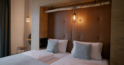 Hängeleuchten erhellen gepolstertes Holzkopfteil im Boutique Hotelzimmer