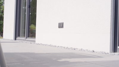 Lichtschalter an einer weißen Fassade neben großen Glastüren Lichtschalter an einer weißen Fassade neben großen Glastüren, moderne Architektur, Schiebetüren und Hauswand als 4K