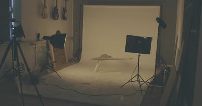 Abgedunkeltes Fotostudio mit Stativen Softboxen und weißer Hintergrundwand