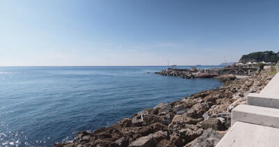 Felsige Uferbefestigung mit hellen Treppenstufen am blauen Meer Felsige Uferbefestigung mit hellen Treppenstufen am blauen Meer, Steinblöcke, Felsufer und Betontreppe als 4K Stockvideo