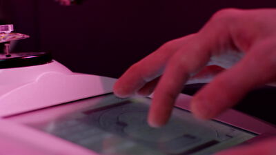 Finger bedient einen beleuchteten Touchscreen an einem Terminal
