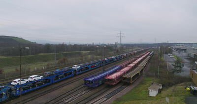 Autozug mit Fahrzeugtransportwagen im Rangierbahnhof von oben