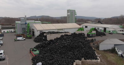 Riesiger Altreifenberg vor einer Recyclinganlage von oben