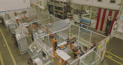 Orangefarbene Roboterzellen in der Fabrikhalle von oben