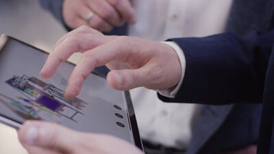 Geschäftsleute besprechen ein digitales Anlagenmodell auf dem Tablet