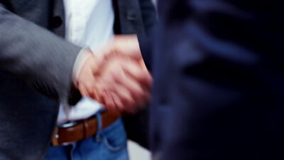 Zwei Geschäftsleute besiegeln eine Vereinbarung mit einem Handschlag