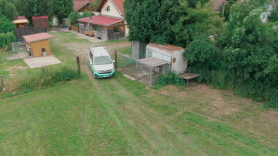 Drohnenflug über einen Kleinbus in einem grünen Gartengrundstück