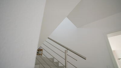 Moderne Treppe mit Edelstahlgeländer in einem hellen Innenraum
