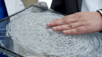 Techniker prüft gesprungene Sicherheitsglasscheibe im Labor