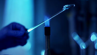 Glaspipette über der Brennerflamme im Labor sterilisieren