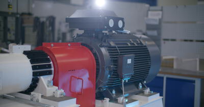 Großer Elektromotor mit rotem Kupplungsschutz in der Prüfhalle