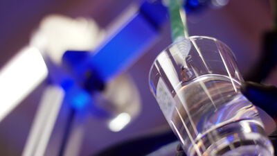 Glasbehälter wird im Labor mit Flüssigkeit befüllt