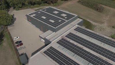 Luftaufnahme großer Photovoltaikanlagen auf Industriedächern