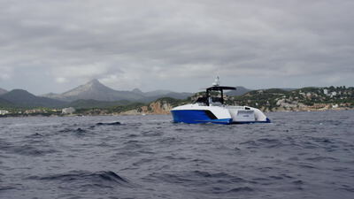Tagesyacht fährt bei bewölktem Himmel entlang einer Bergküste