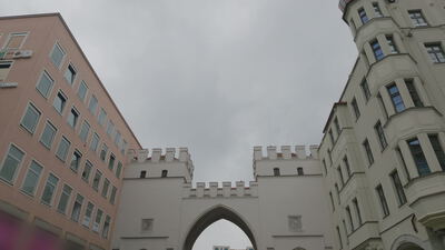 Historisches Stadttor mit Zinnen zwischen Häuserfassaden: historisches Stadttor, Stadttor mit Zinnen