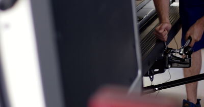Person stellt Widerstand an einem Fitnessgerät im Fitnessstudio ein