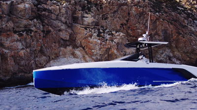 Blaues Motorboot fährt dicht an einer schroffen Steilküste entlang: Motorboot an der Steilküste, Steilküste