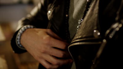 Mann in schwarzer Lederjacke mit silbernem Armband
