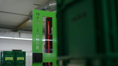 Grüner Industrieturm mit roter LED Anzeige in der Lagerhalle