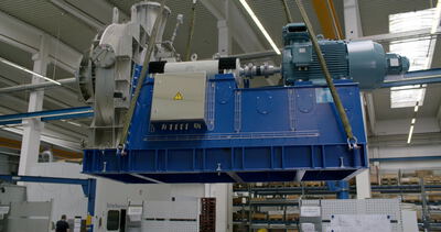 Großer Radialventilator hängt an Hebegurten eines Krans in der Fabrik