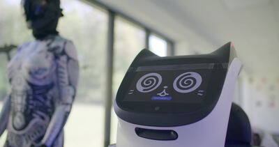 Ein Serviceroboter mit digitalem Katzengesicht steht in einem modernen Büro