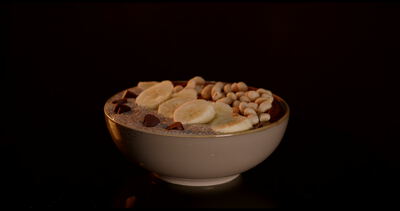 Cremige Schokoladenbowl mit Banane und gehackten Nüssen dreht sich