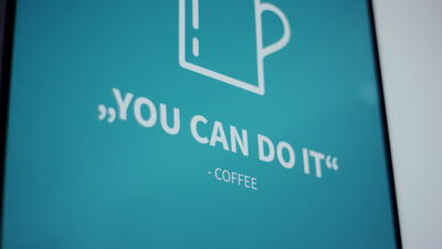 Türkises Kaffeeschild mit einem Spruch und einer Tasse