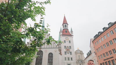 Rathausturm ragt hinter grünen Baumzweigen in der Altstadt empor