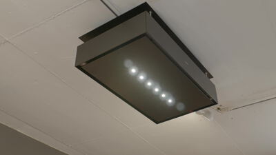 Dunkle Pendelleuchte an der Decke schaltet ihre LED Lichter nacheinander ein