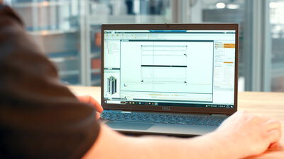 Konstrukteur entwirft eine Werkbank am Laptop in der Lagerhalle