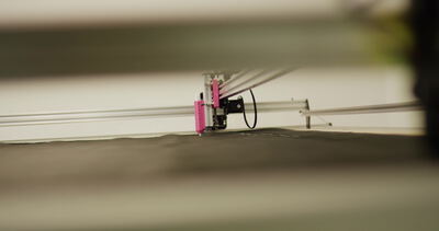 Automatischer Plotter gleitet flach über dunkles Material