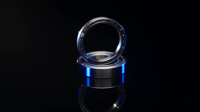 Glänzendes Kugellager mit blauem Ring vor schwarzem Hintergrund