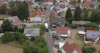 Drohnenaufnahme eines Wohngebiets mit roten Ziegeldächern und Solaranlagen
