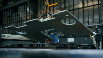 Großes Stahlblech wird an einem Kettenzug in der Metallfabrik gehoben