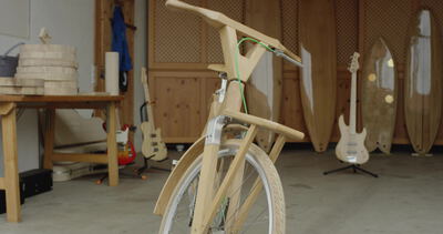 Handgefertigtes Fahrrad aus hellem Holz steht in einer Werkstatt