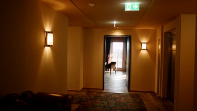 Warmer Hotelflur mit Wandleuchten und gemustertem Teppich Warmer Hotelflur mit Wandleuchten und gemustertem Teppich, Hotelkorridor, Hotel Flur Luxus und Wandleuchten Hotel als 4K