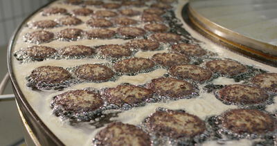 Frikadellen braten in der großen runden Fritteuse