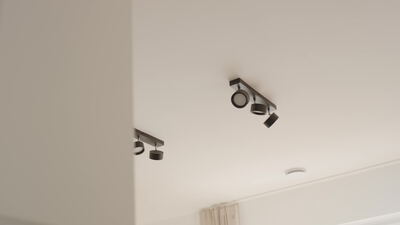 Schwarze Deckenstrahler an einer weißen Decke im modernen Wohnraum