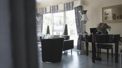 Elegantes Wohnzimmer mit schwarzem Flügel und Ledersesseln