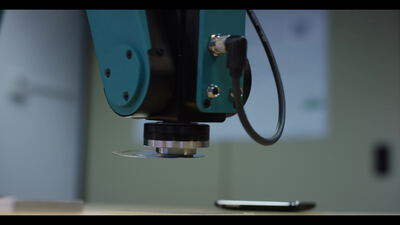 Industrieroboter positioniert präzise ein Werkzeug über einem Metallteil Industrieroboter positioniert präzise ein Werkzeug über einem Metallteil, industrieroboter in der fertigung, roboterarm