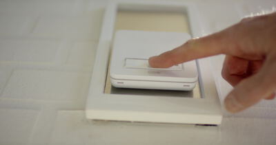 Finger drückt einen modernen smarten Lichtschalter Finger drückt einen modernen smarten Lichtschalter, Lichtschalter drücken, smarter Lichtschalter und Smart Home Schalter als