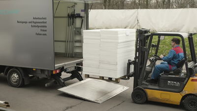 Gabelstapler belädt Lieferwagen mit Dämmplatten im Werkhof Gabelstapler belädt Lieferwagen mit Dämmplatten im Werkhof, Lieferwagen beladen, Gabelstapler im Einsatz und Palette