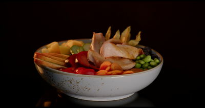 Bunte Bowl mit Edamame Paprika und Fleischstreifen dreht sich