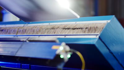 Naturfasern auf blauer industrieller Verarbeitungsmaschine Naturfasern auf blauer industrieller Verarbeitungsmaschine, Faserverarbeitung, Industriemaschine blau und Faserproduktion
