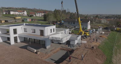 Luftaufnahme einer Baustelle mit Kran beim Bau moderner Häuser, luftaufnahme baustelle, drohnenaufnahme hausbau und kran