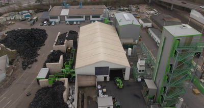 Reifenrecyclinghof mit Schredder und Gummibergen von oben