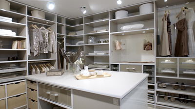 Luxuriöses Ankleidezimmer mit Insel und hängenden Kleidern Luxuriöses Ankleidezimmer mit Insel und hängenden Kleidern, begehbarer Kleiderschrank, Garderobe Innenraum und