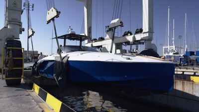 Blaues Motorboot wird am Kai aus dem Wasser gehoben