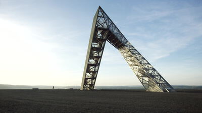 Stählernes Wahrzeichen auf einer Bergehalde im Abendlicht Stählernes Wahrzeichen auf einer Bergehalde im Abendlicht, Wahrzeichen Bergehalde Aufnahmen, stählernes Monument lizenzfrei