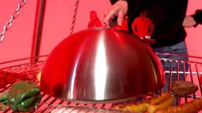 Silberne Cloche gibt in roter Food Art Szene eine Pizza frei